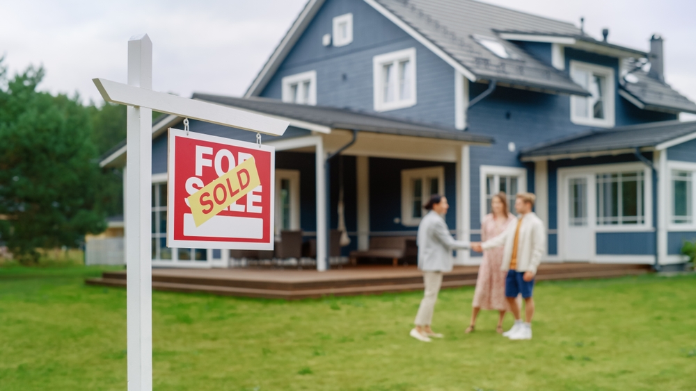 Cash for home sellers shaking hands with Investor infront of their home.