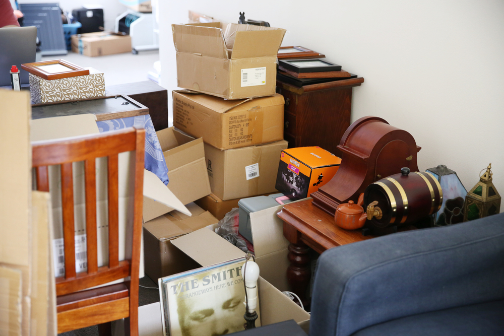 Stacks of moving boxes and various household items depicting relocation