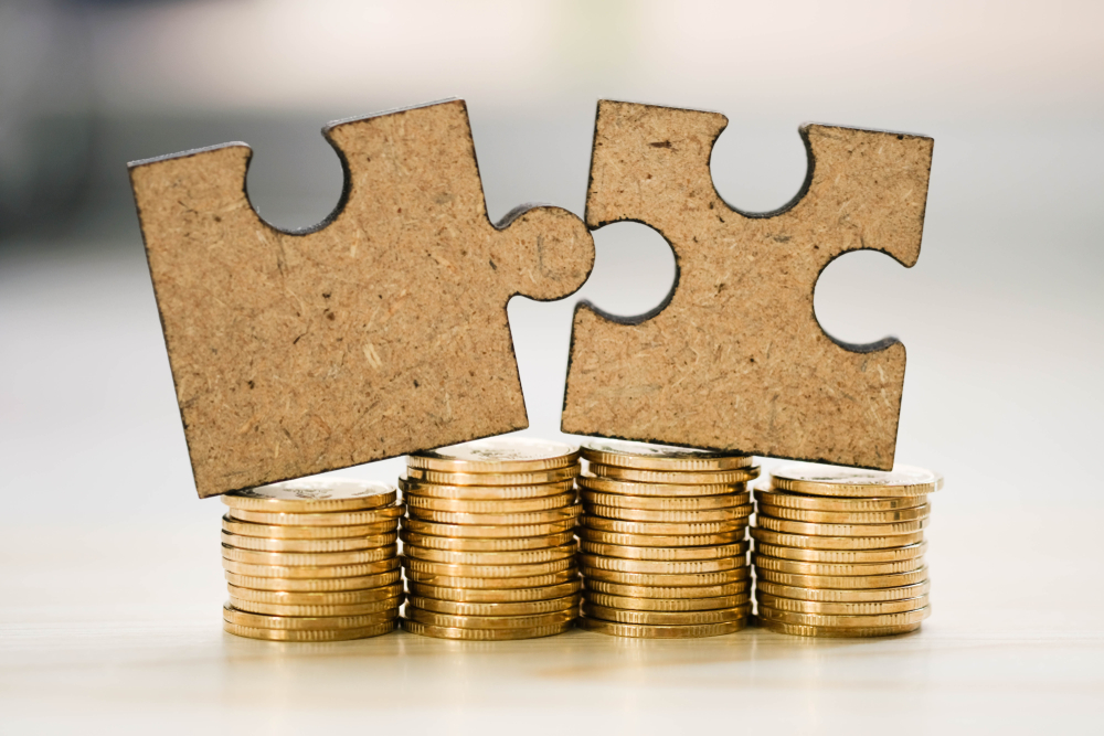 Puzzle pieces atop stacks of coins, symbolizing the fitting solution of home cash offers.