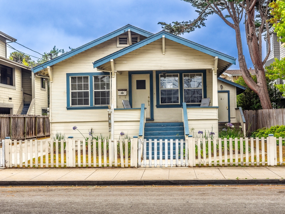 Photograph of an old model home available for a cash offer.