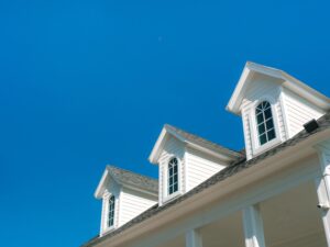 Close-up of white home gables with clear blue sky in the background.